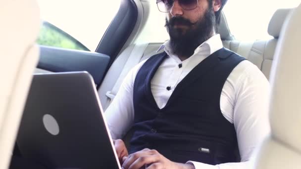 자동차 뒷자리에서 노트북을 가지고 일하는 인도 사업가 — 비디오