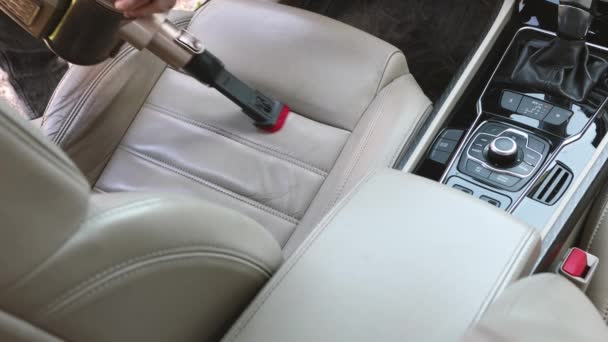 Servizio di pulizia interni auto professionale. Primo piano di un dettagliato aspirapolvere di sedili in pelle leggera in una berlina di lusso — Video Stock