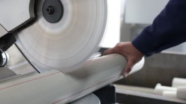 Fabrika işçisi dairesel testere ile polipropilen boru kesiyor. Polipropilen boru deposu. Plastik boru üretmek için ekstrakarların olduğu bir atölye