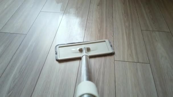 Lavar o piso laminado com uma esfregona. Limpeza do chão com esfregão em casa. Conceito de cuidados no chão. Visão em primeira pessoa — Vídeo de Stock