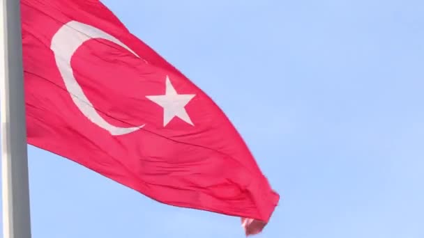 Grote Turkse nationale vlag wapperend in de wind op een vlaggenmast tegen de lucht — Stockvideo