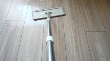 Mikrofiber Toz Paspası zeminin etrafında hareket ediyor. Ev zeminini temizleyen paspasın üst görünüm POV 'u.