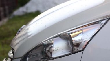 Elle araba yıkama, bir adam arabasını özel şampuanla yıkar. Araba yüzeyine deterjan sıkıyorum. Araç Bakımı