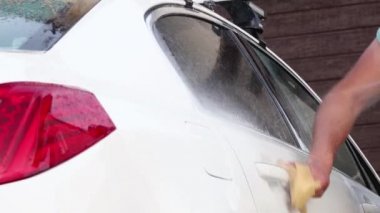 El yıkaması, özel bir hortumla arabasını yıkayan bir adam. El ile taşınabilir araba yıkama. Ayrıntılı ve nazik araba bakımı