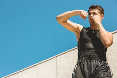 Egzersiz yapan ve dışarıda dövüşen, eldivenli bir boksör. erkek boksör portresi