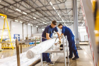 Fabrikada üretilen koruyucu tulumlu profesyonel işçiler paketleyip paketliyor.