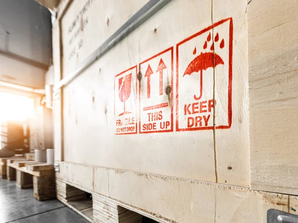 Bright red special marking symbols on wooden boxes with goods inside, prescribing careful handling of the cargo — Stock Photo, Image