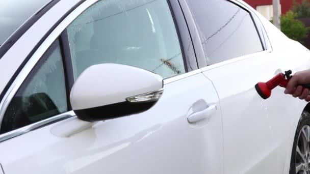 Manual car wash. A man washes his sedan from a special hose. Manual portable car wash. Detailed and gentle car care — Stock Video