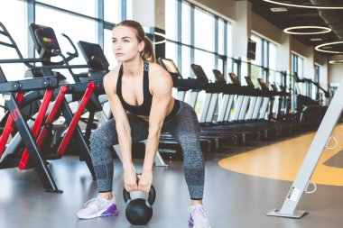 Spor salonunda halter ağırlıklarıyla çalışıyor. Spor yapan kadınlar halterleri kaldırıyor. Fitness kaslı vücut. Spor salonunda egzersiz..