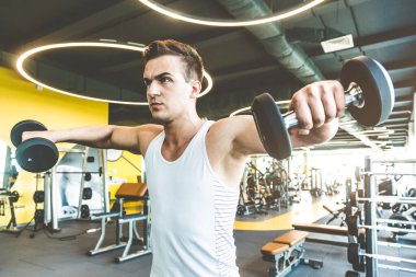 Spor salonunda halter ağırlıklarıyla çalışıyorum. Spor yapan erkekler halterleri kaldırıyor. Fitness kaslı vücut. Spor salonunda egzersiz..