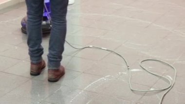 Temizlikçi rıhtımı profesyonel bir cilalama makinesiyle yıkıyor. Ofis binasının zeminini temizliyorum.
