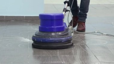 Temizlikçi rıhtımı profesyonel bir cilalama makinesiyle yıkıyor. Ofis binasının zeminini temizliyorum.
