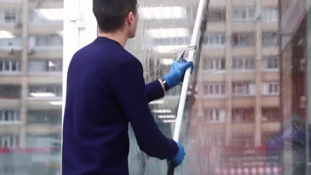 Професійне мило для чищення вікон і стискає чисте вікно, працівник прибирання чоловіків . — стокове відео