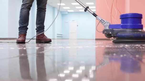 De reiniger wast een pier met een professionele polijstmachine. Schoonmaakvloer in kantoorgebouw lobby — Stockvideo