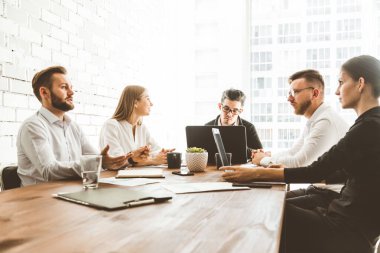 Ofiste birlikte çalışan ve iletişim kuran genç iş adamlarından oluşan bir ekip. Şirket buharı ve bir toplantıda yönetici..