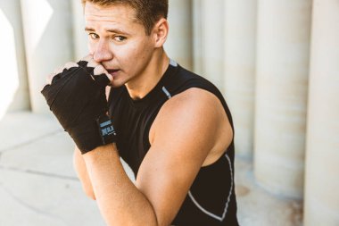 Egzersiz yapan ve dışarıda dövüşen, eldivenli bir boksör. erkek boksör portresi