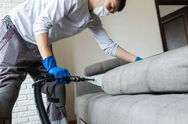 Mann reinigt Sofa chemische Reinigung mit professioneller Extraktionsmethode. Polstermöbel. Frühjahrsputz oder regelmäßiges Aufräumen. — Stockfoto