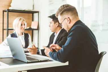 Ofiste birlikte çalışan ve iletişim kuran genç iş adamlarından oluşan bir ekip. Şirket buharı ve bir toplantıda yönetici..