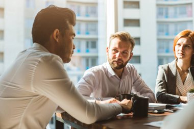 Ofiste birlikte çalışan ve iletişim kuran genç iş adamlarından oluşan bir ekip. Şirket buharı ve bir toplantıda yönetici..