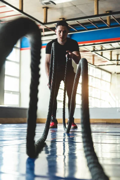 Kötéllel keresztezve. A sportoló a tornateremben edz a nagy panoráma ablakokkal szemben.. — Stock Fotó