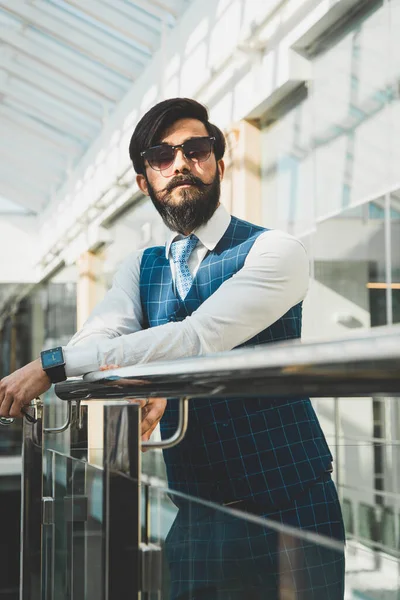 Retrato de un hombre de negocios en traje están de pie en el fondo de las oficinas de vidrio. — Foto de Stock