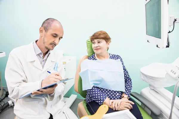 Dentistry concept. Professional dental services and modern equipment without pain. The doctor consults and treats an elderly woman.