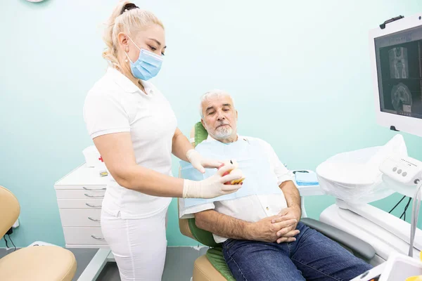 Dentistry concept. Professional dental services and modern equipment without pain. A doctor consults and treats an elderly man.