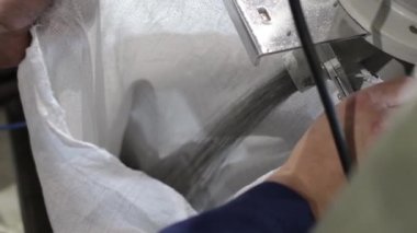 Fabrika işçisi bir çantayı polipropilen granüllerle dolduruyor. Fıçı PP Pet Chips Semi Dull, PET Cipsleri geri dönüşüm, PET Polyester Cipsler