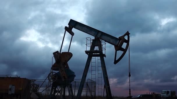 Silhouette Saugnäpfe Pumpenarbeit und Ölpumpe vor dem Hintergrund des Abendhimmels — Stockvideo