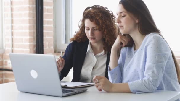 Dos mujeres jóvenes trabajan juntas en la oficina. Trabajo en equipo, reunión de negocios. Freelancers trabajan. — Vídeos de Stock