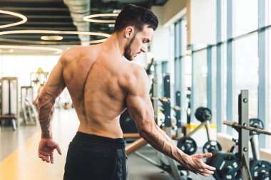 Spor salonunda çıplak poz veren yakışıklı sporcu erkek vücut geliştirici.