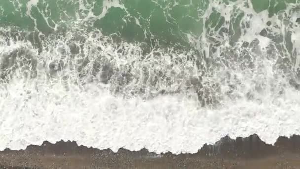 Аэрофотосъемка с беспилотника. Летит вдоль побережья. Приливная волна. Волны катятся над берегом крупным планом сверху и пеной. — стоковое видео