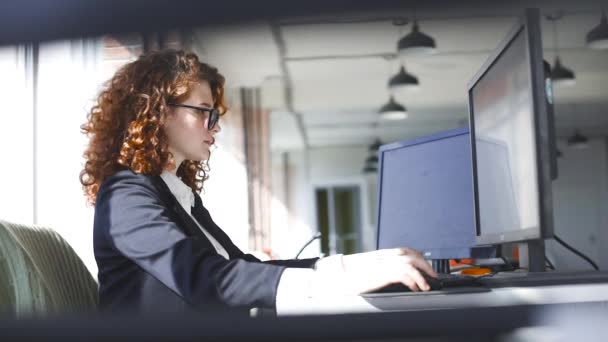 La joven trabaja en la computadora de la oficina. Empresaria trabajadora — Vídeos de Stock
