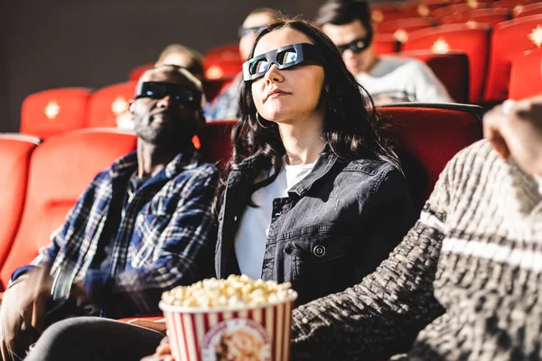 Los amigos están viendo una película en el cine. La gente se sienta en los sillones del cine y mira la pantalla con gafas especiales para 3D — Foto de Stock