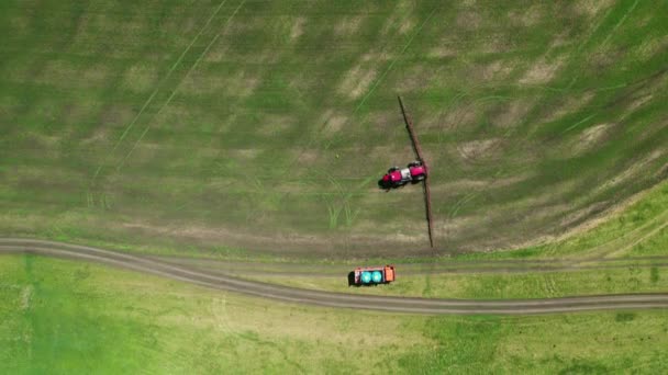 4K畑を耕す農業機械の空中ビュー。特殊な機械トラクターは害虫から将来の作物を噴霧します — ストック動画