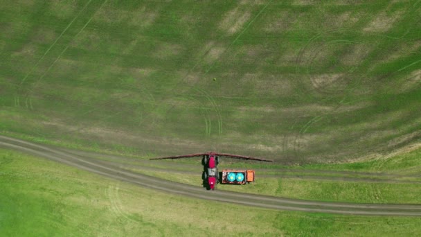 4K畑を耕す農業機械の空中ビュー。特殊な機械トラクターは害虫から将来の作物を噴霧します — ストック動画