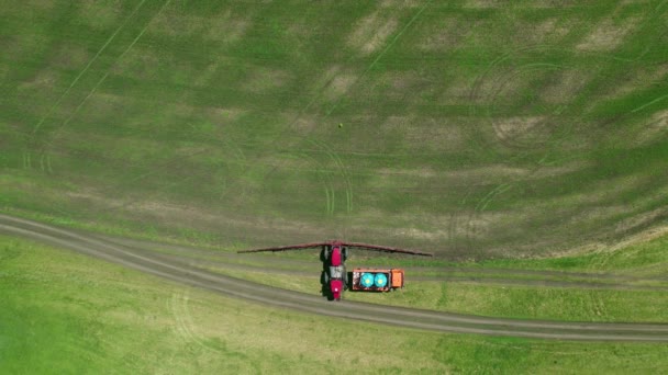 4K Vue aérienne des machines agricoles cultivant le champ. Un tracteur spécial pulvérise la future récolte contre les ravageurs — Video