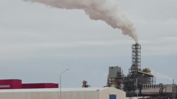 Industriområde med ett rör tjock vit rök hälls från fabriksledningen i motsats till solen. Föroreningar av miljön: en rökpipa — Stockvideo