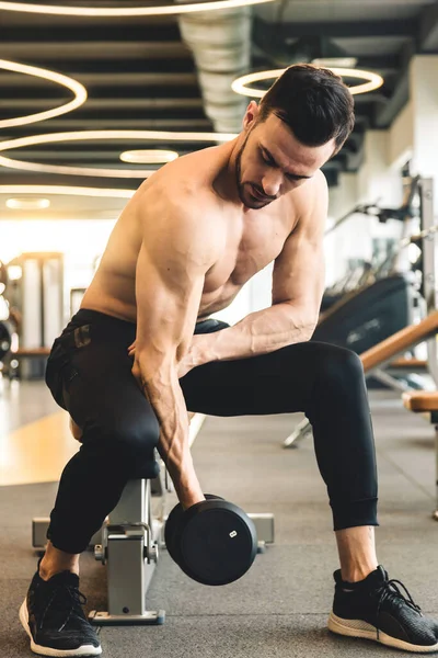 Jóképű fiatal sportos férfi testépítő gyakorló súlyzók az edzőteremben — Stock Fotó