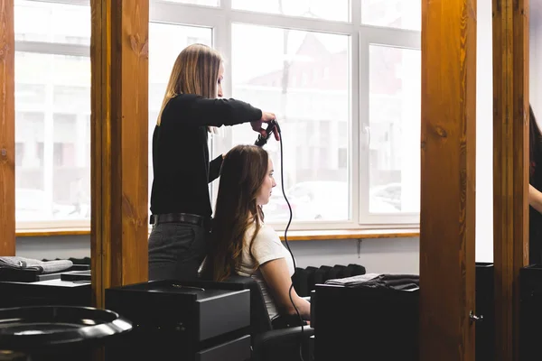 Cabeleireiro mulher mestre suavemente cachos cabelo curling menina em um salão de beleza. Estilo de cabelo — Fotografia de Stock