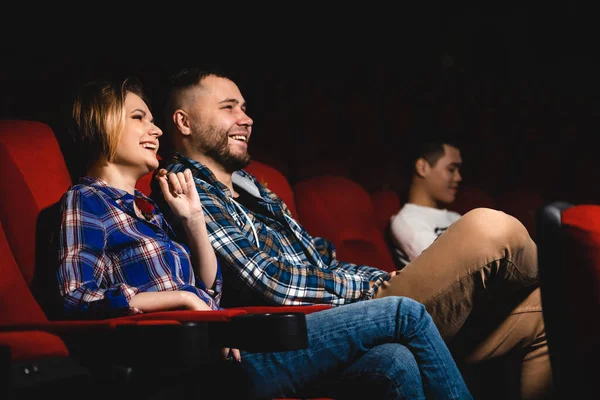 Los amigos están viendo una película en el cine. La gente se sienta en los sillones del cine y mira la pantalla — Foto de Stock