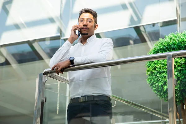 Retrato de un hombre de negocios en traje están de pie en el fondo de las oficinas de vidrio. — Foto de Stock