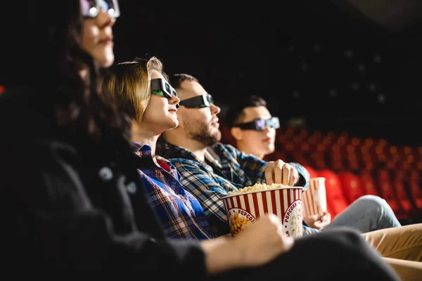 Los amigos están viendo una película en el cine. La gente se sienta en los sillones del cine y mira la pantalla con gafas especiales para 3D — Foto de Stock