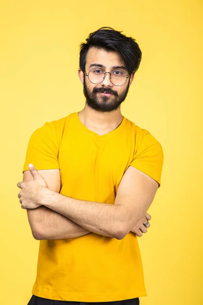 Retrato emocional de um homem hindu em uma camiseta amarela em um fundo laranja brilhante — Fotografia de Stock