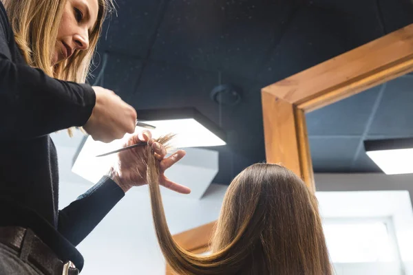 Le maître coiffeur coupe les extrémités des cheveux après le lavage et dans le salon de beauté. — Photo
