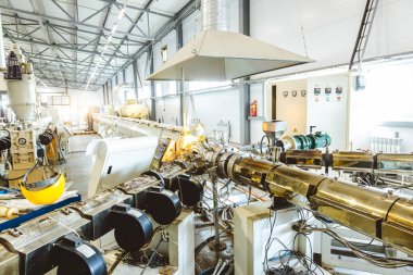 Plastik boru üretmek için ekstrakarların olduğu bir atölye. Su tedarik ve gaz borularından yüksek hızda ekstrüzyon hattı. Üretim tesisi.