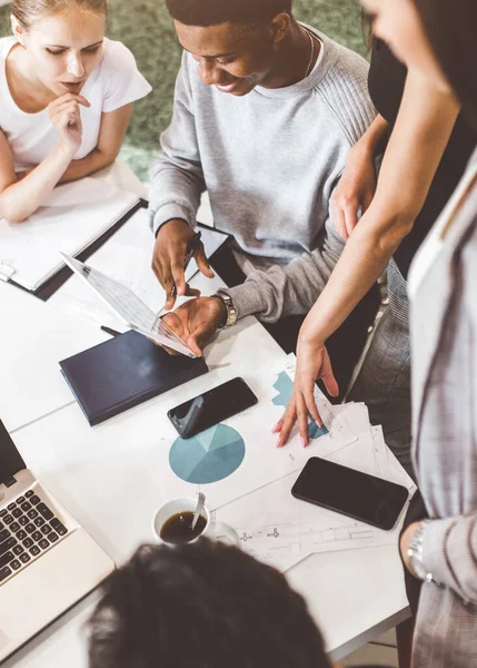 Un equipo de jóvenes trabajadores de oficina, empresarios con portátil trabajando en la mesa, comunicándose juntos en una oficina. Corporativosvapor y gerente en una reunión. coworking. — Foto de Stock