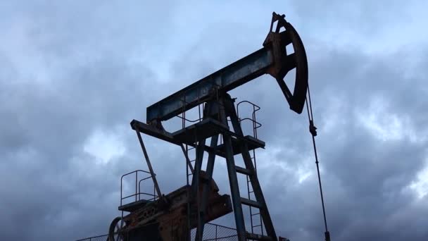 Trabajo de la bomba de barra de succión de silueta y aceite de la bomba contra el fondo del cielo de la noche — Vídeos de Stock