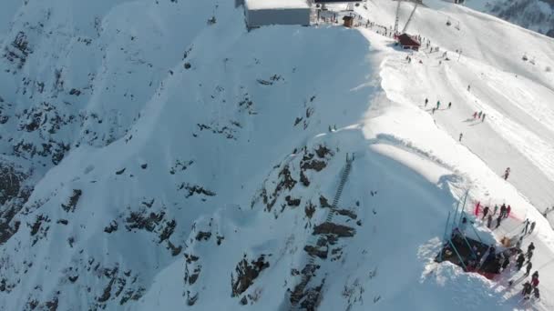 Utsikt från skidanläggningens höjd. Drone flyger över toppen av berget och människor — Stockvideo