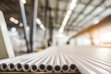 Polipropilen boru deposu. Plastik boru üretmek için ekstrakarların olduğu bir atölye. Su tedarik ve gaz borularından yüksek hızda ekstrüzyon hattı. Üretim tesisi.